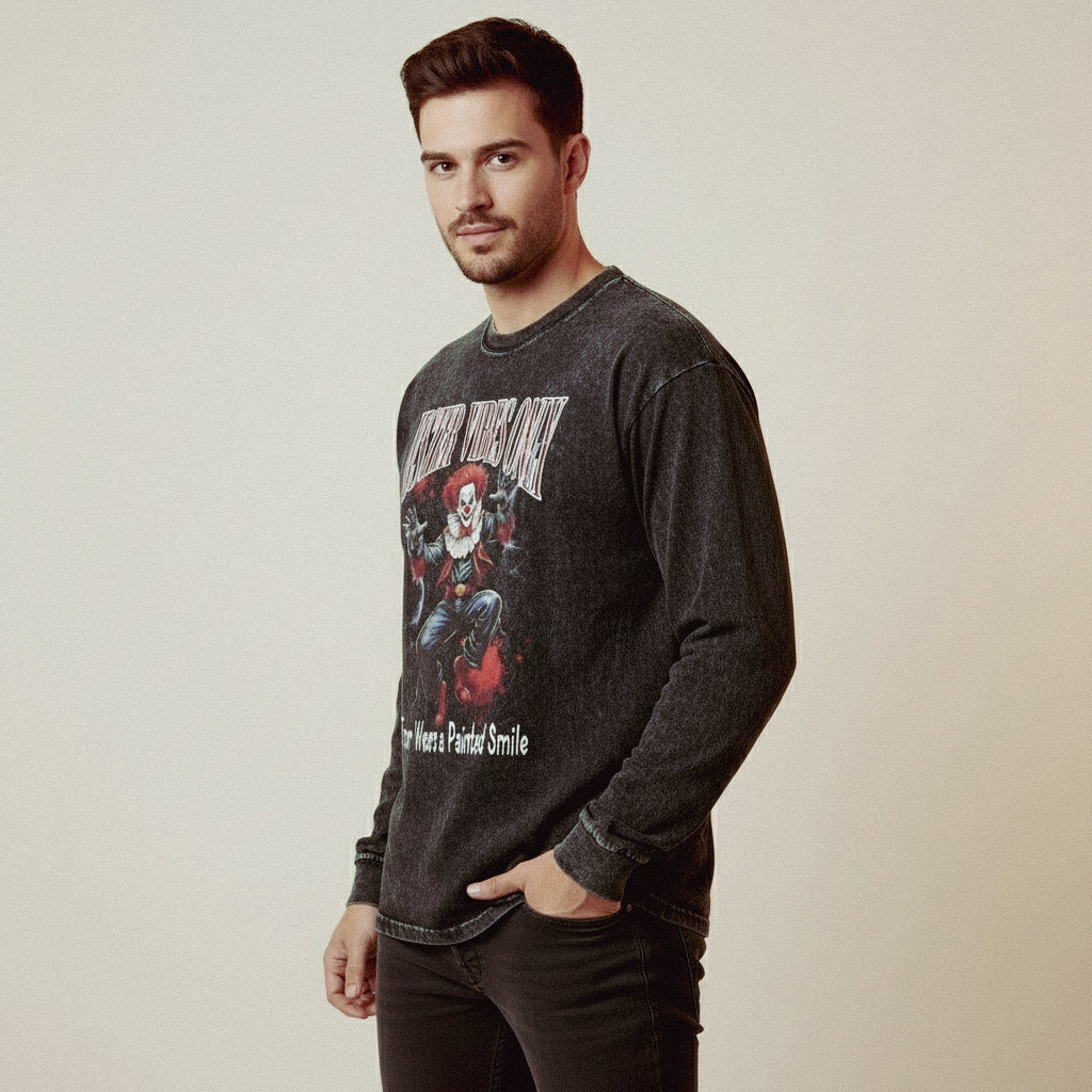 Man wearing a dark gray long-sleeve shirt with graphic design on a plain background
