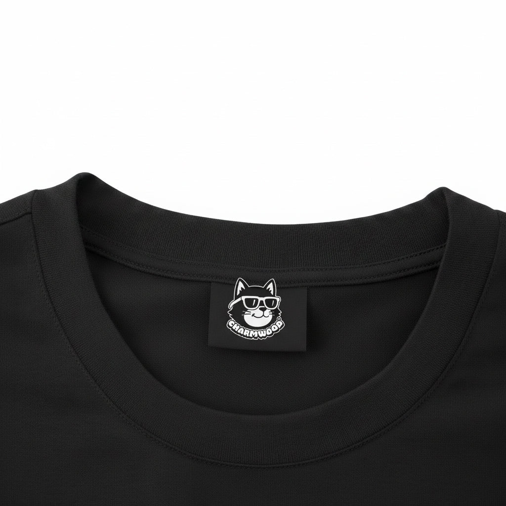 a close-up view of a black t-shirt with a small white label featuring a cat wearing sunglasses.
