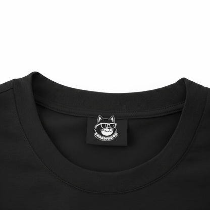 a close-up view of a black t-shirt with a small white label featuring a cat wearing sunglasses.