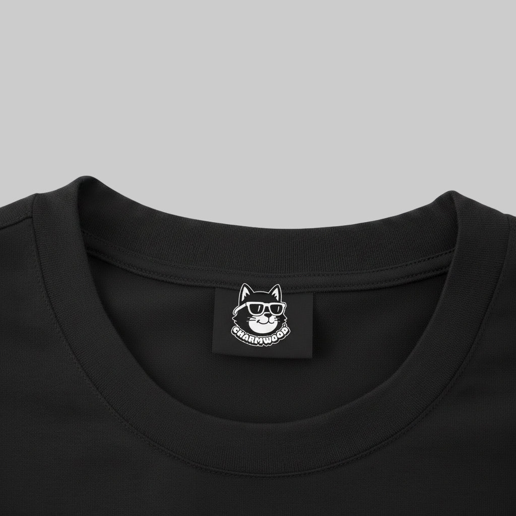 a close-up view of a black t-shirt with a small white label featuring a cat wearing sunglasses.