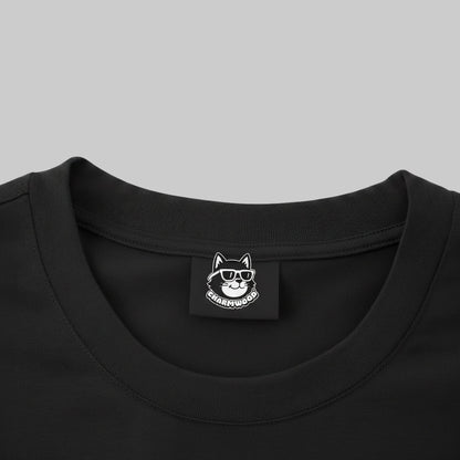 a close-up view of a black t-shirt with a small white label featuring a cat wearing sunglasses.