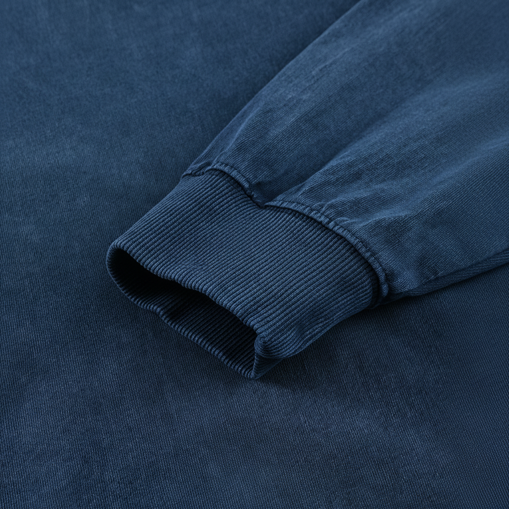 A close-up view of a dark blue fabric, possibly a sweater or a shirt, with a textured appearance.