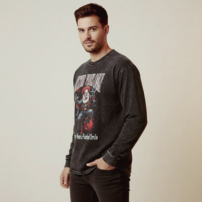 Man wearing a dark gray long-sleeve shirt with graphic design on a plain background