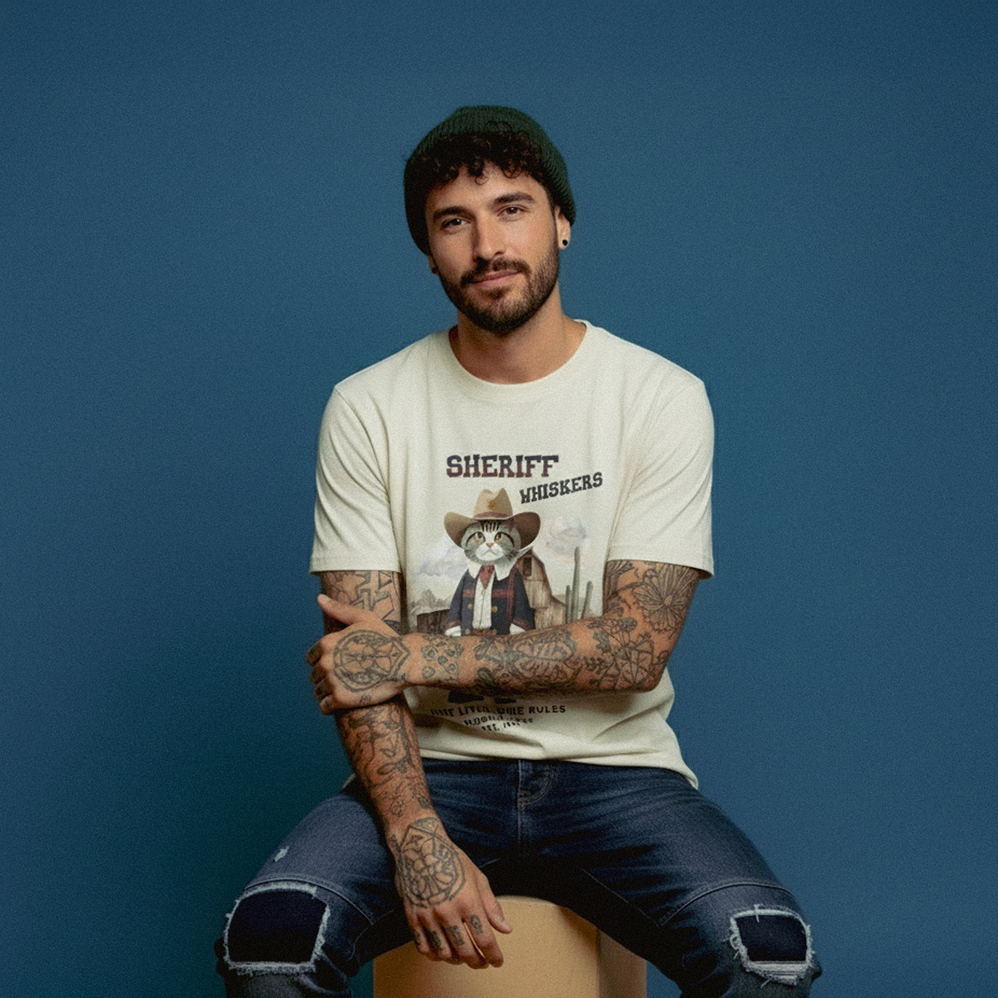 Man wearing a t-shirt with a graphic design sitting on a blue background