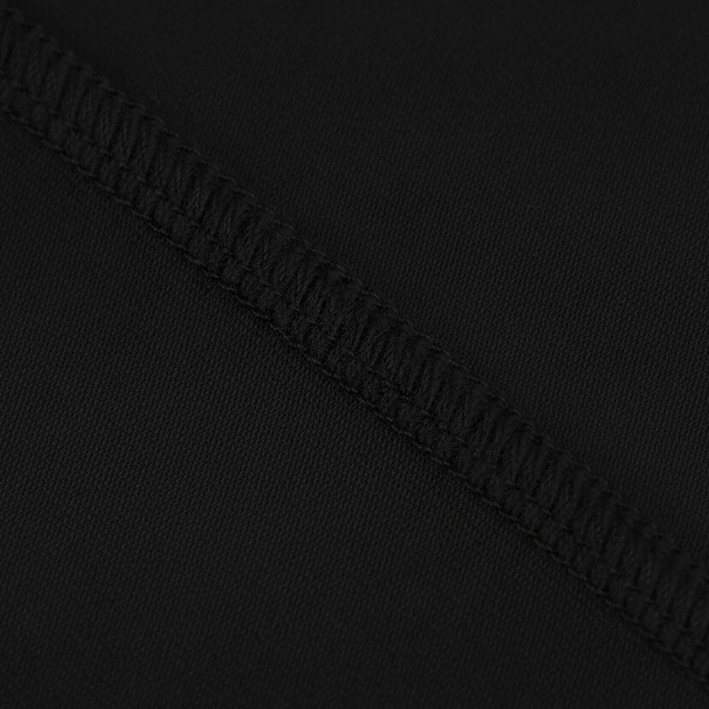 A close-up view of a black fabric with a diagonal stitching pattern.