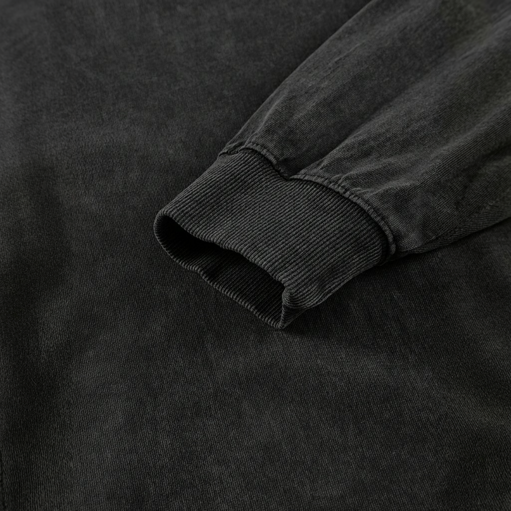 A close-up view of a black fabric, possibly a sweater or shirt, with a textured appearance.