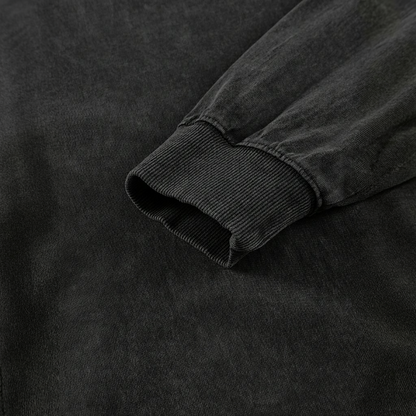 A close-up view of a black fabric, possibly a sweater or shirt, with a textured appearance.