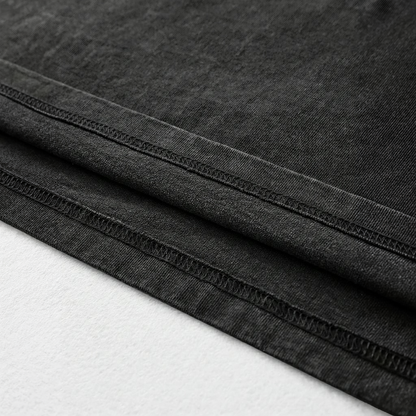 A close-up view of a black fabric, possibly denim, with visible stitching and folds.
