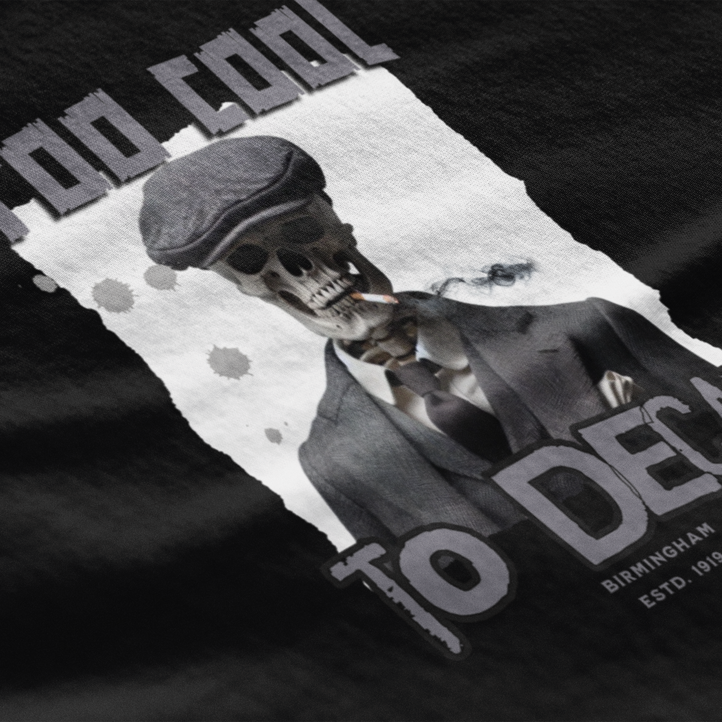 Black t-shirt with a skeleton wearing a cap and text 'Too Cool to Decay' on a dark background